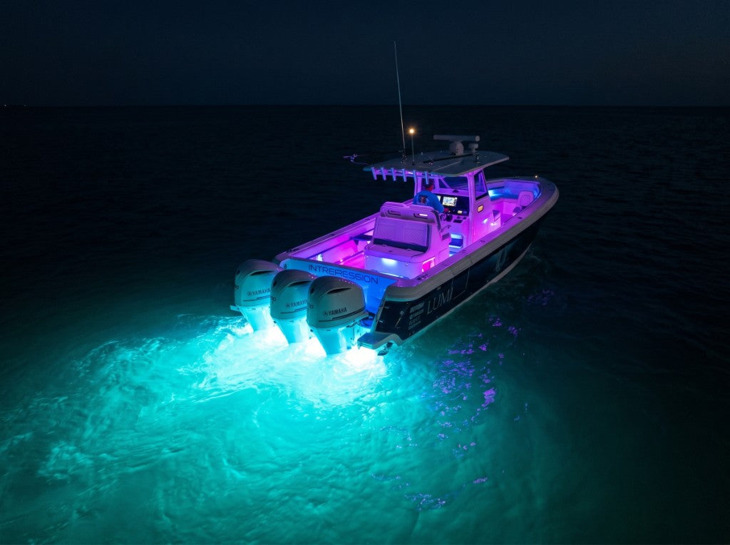 Boat at night with SeaBlaze X2 Spectrum underwater lighting in cyan and magenta